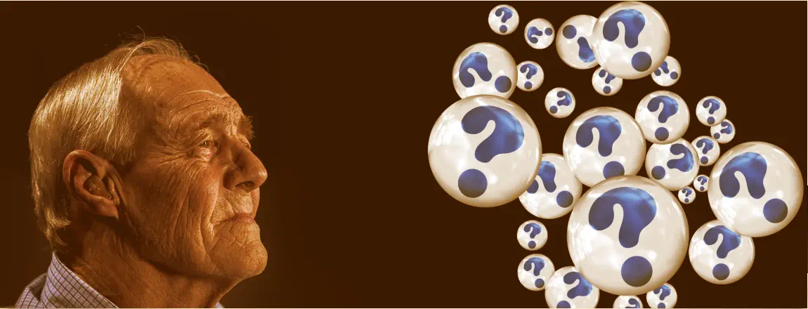 Alter Mann, der auf Kugeln mit Fragezeichen schaut